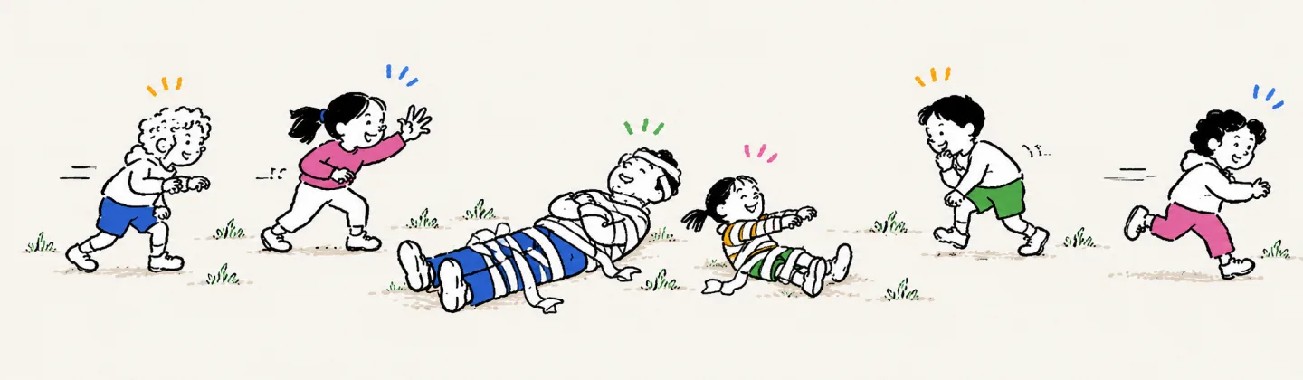 A grown-up and a kid wrapped as mummies lie on the grass, the kid just sitting up with stiff arms, while four kids circle them at a careful distance