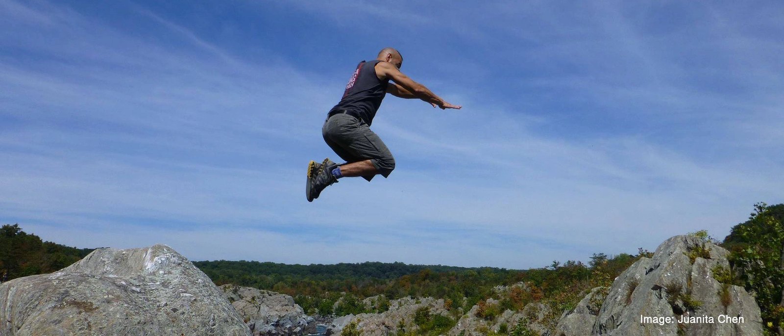 Mark Toorock leaping between boulders at Great Falls. Photo credit Juanita Chen.
